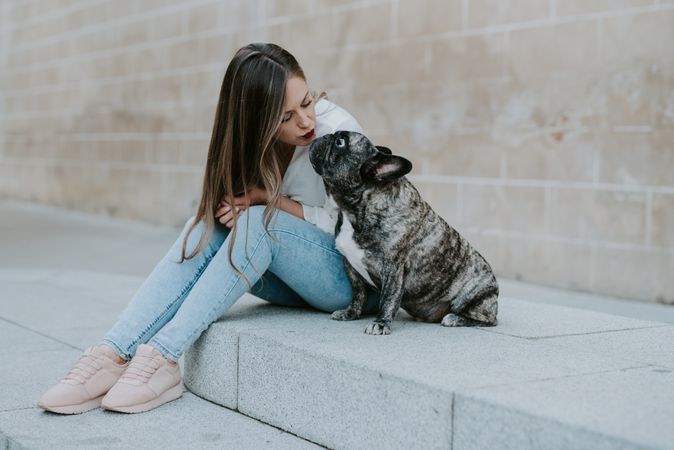Woman with cute bulldog on street