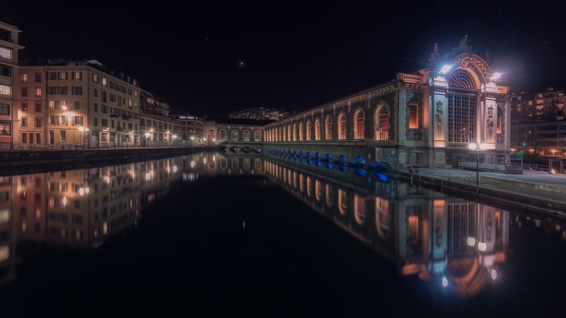 Illuminated buildings on city embankment in night
