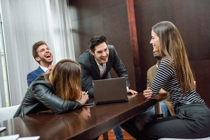 Businessmen and woman laughing over something in a meeting room