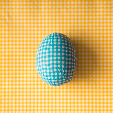 Blue checkered Easter egg with yellow background
