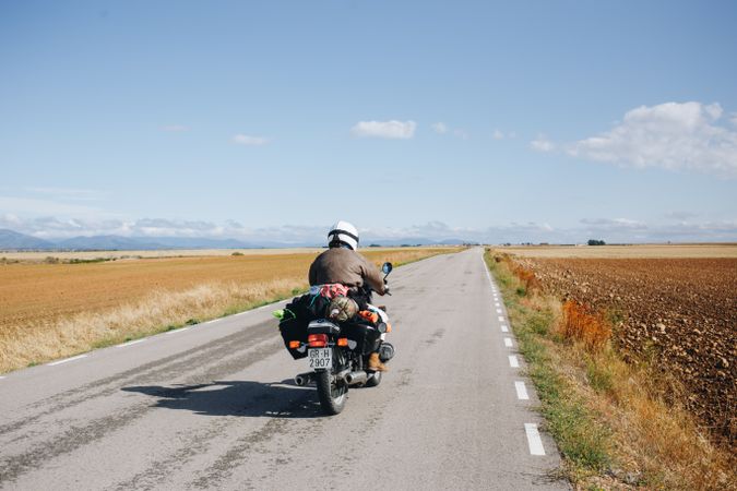 Man on motorcycle on vast rural road