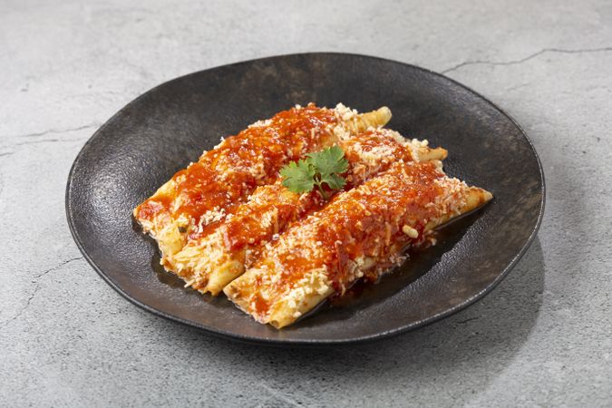 Pancakes stuffed with minced meat and topped with tomato sauce and grated cheese.