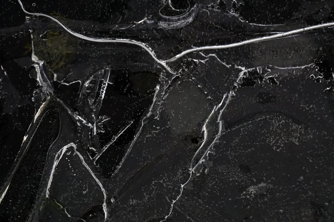Fragment of thin ice on dark frozen river