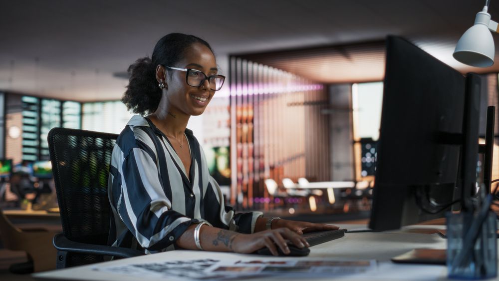 Black Woman Working on Desktop Computer in Creative Office.