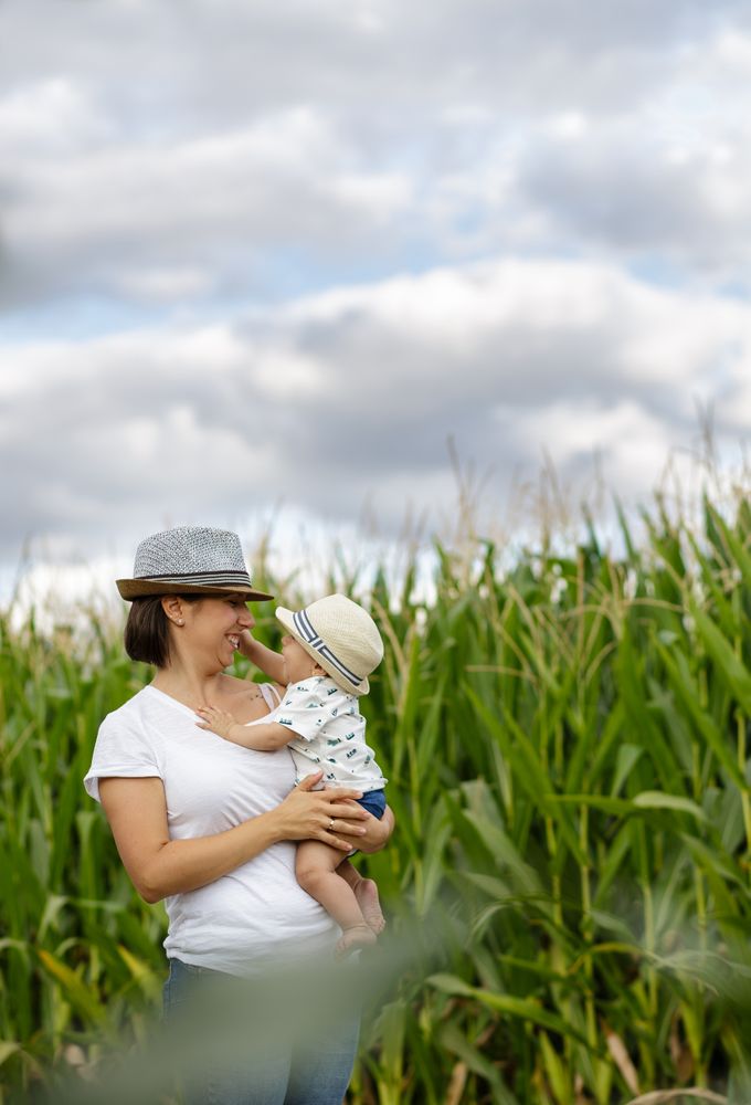 Adorable mother and child on hand enjoying and laughing in field