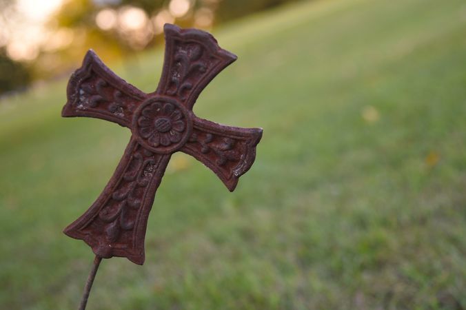 a leaning metal cross in a cemetery