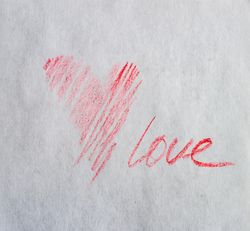 Valentine Day holiday card concept with red heart and love scribbled on paper