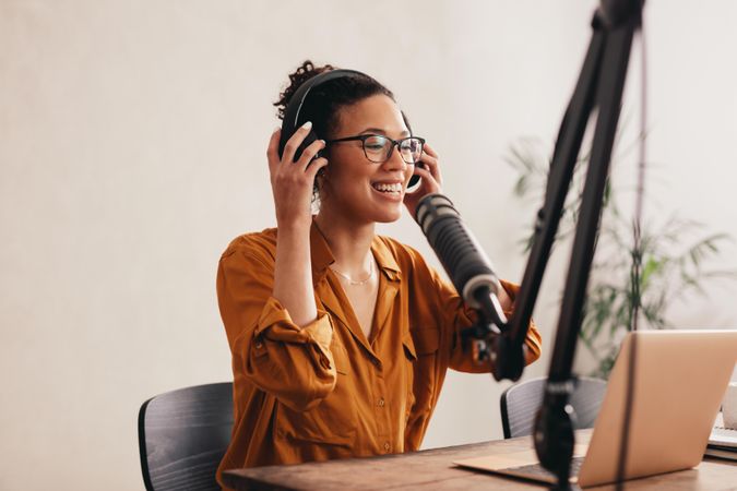 Woman wearing headphones preparing to record a podcast from home studio