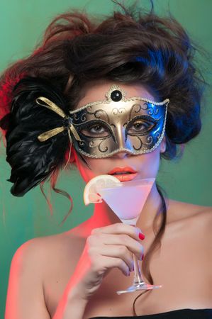 Woman in mask holding glass of drink