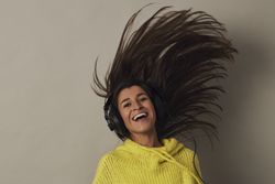 Shocked young woman listening to music in studio