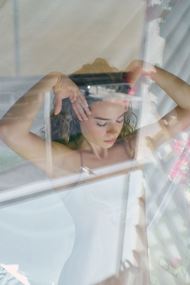 Young woman in nightie touching hair