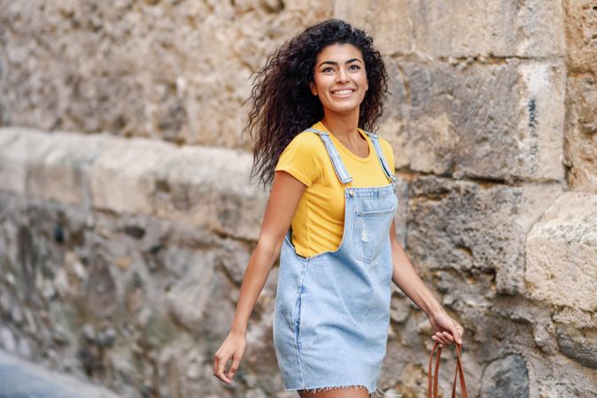 Smiling Arab woman strolling through European street
