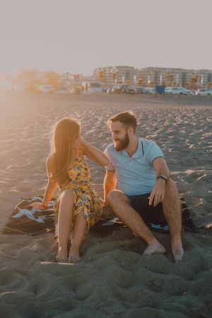 Tender couple talking and chilling in sunlight on towel beach