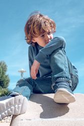 Boy sitting on rock in nature