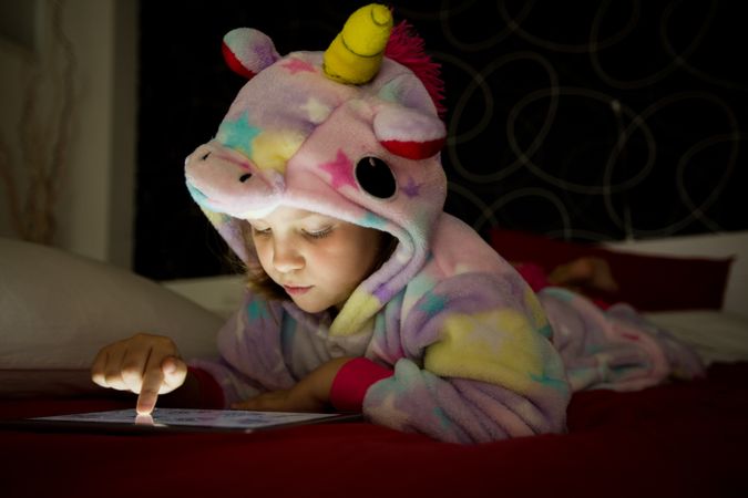 Girl using tablet on bed