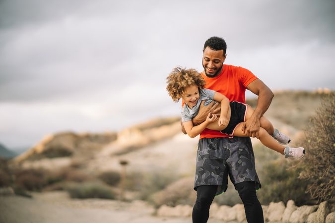 Black father holding child in arms