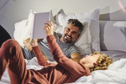 Laughing father and son reading bedtime story together