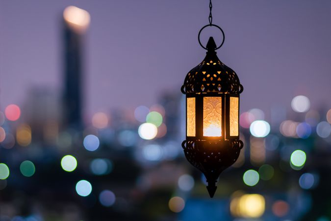 Decorative Lantern Illuminated With City Lights in the Background at Evening