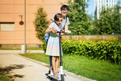 Laughing mother and daughter on a scooter together