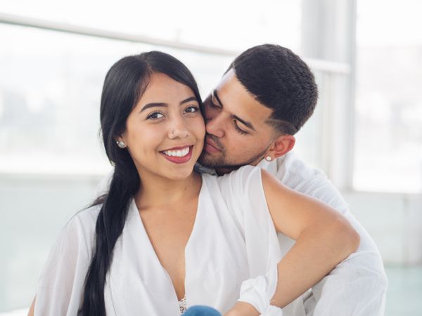 Man embracing smiling woman with love and tenderness