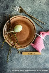 Easter table setting on grey counter with decorative small yellow egg and pink rabbit ornament 4NENBe