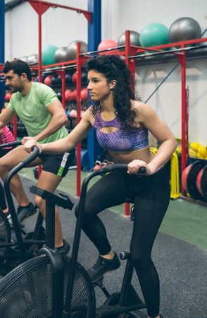 Sportswoman doing air bike at the gym
