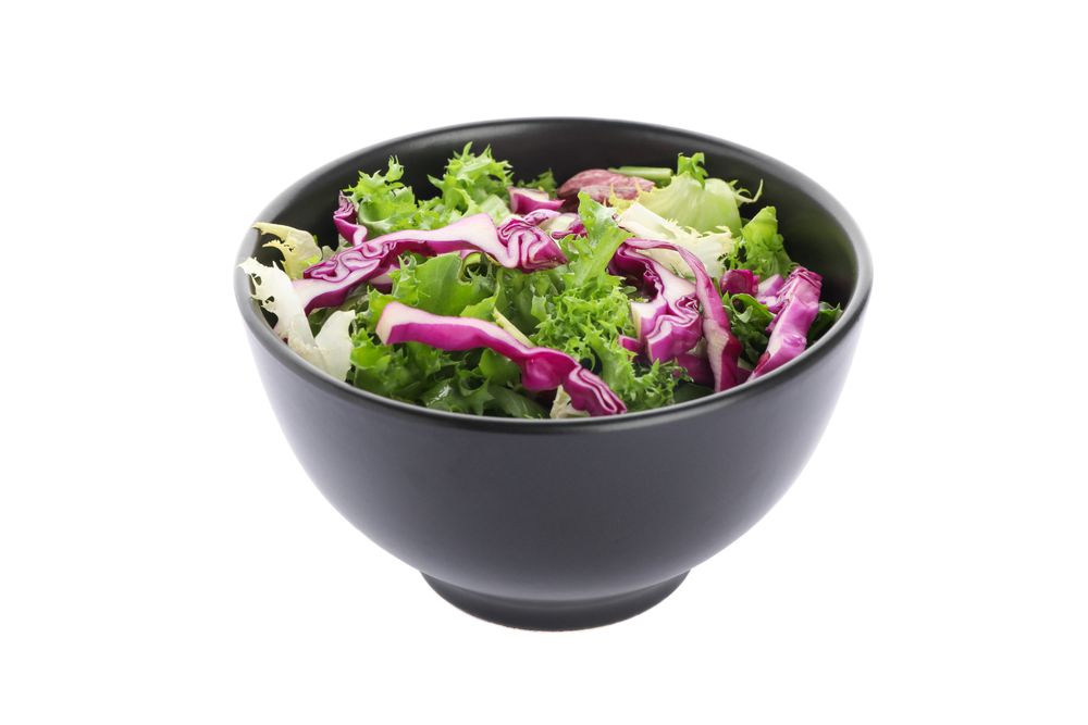 Black bowl with fresh salad isolated on blank background