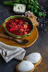 Ukrainian beetroot soup borscht in green bowl with crackers