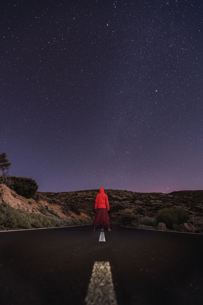 Traveler standing on empty road at night