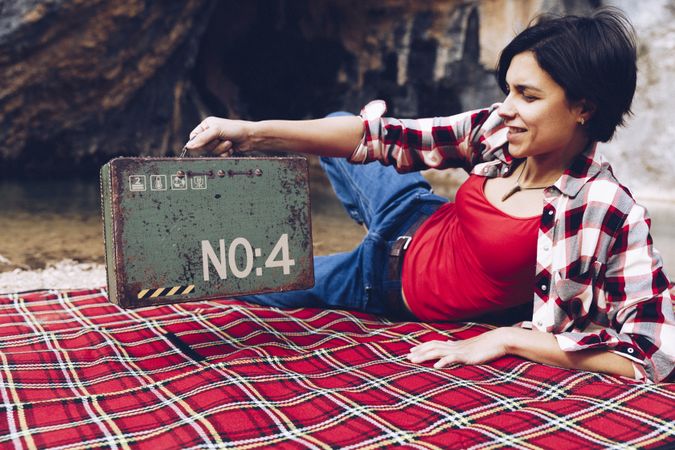 Cheerful woman with old case on picnic