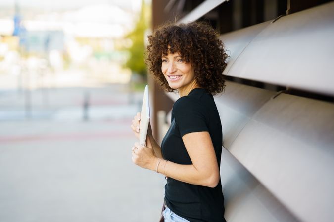 An Enthusiastic and Joyful Young Woman with Beautiful Curly Hair Posing Outdoors in Nature