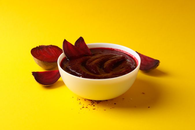 Bowl of borscht or beetroot soup on yellow table