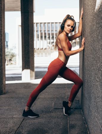 Woman doing stretching exercise by a wall