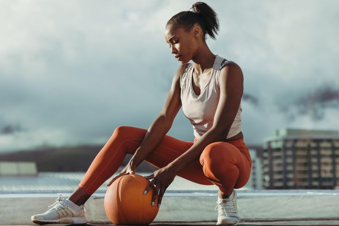 Young beautiful woman holding medicine ball after workout