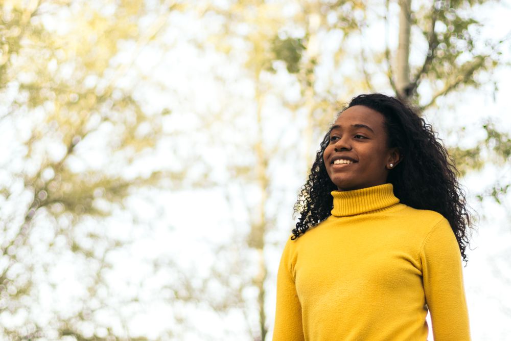 Black woman walking and smiling in a park