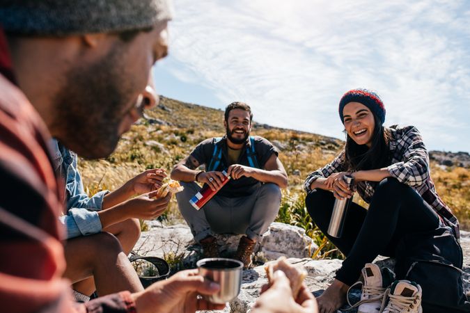 Group of people relaxing and eating lunch on hike