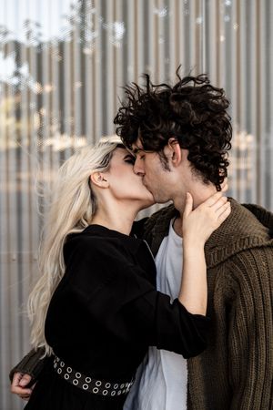 Happy loving couple having fun while kissing on street