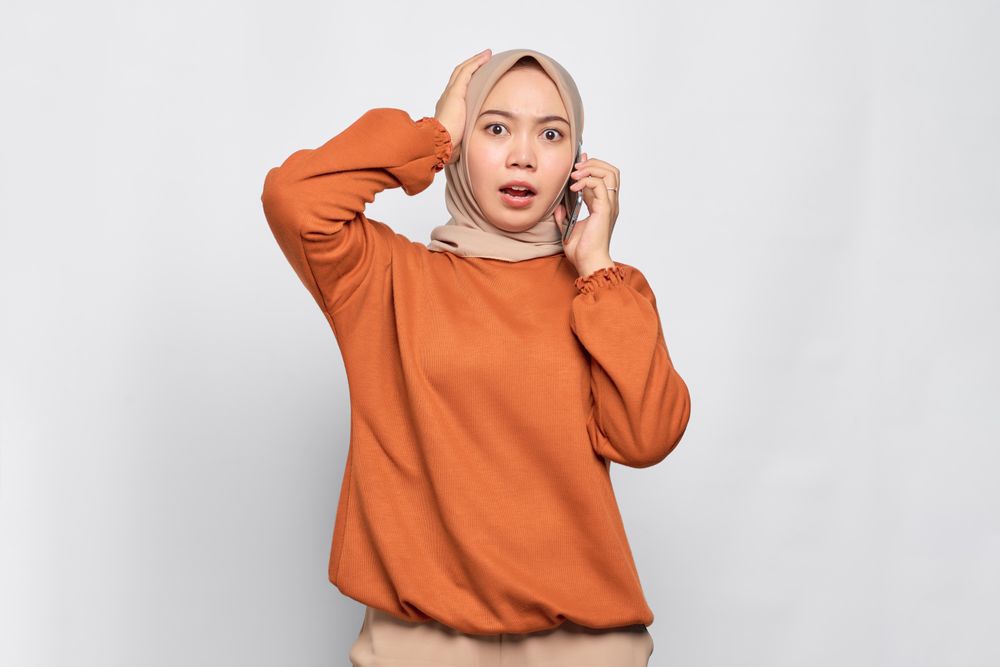 Muslim woman receiving surprising news on cell phone