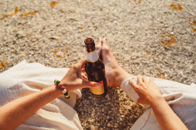 Woman relaxing and drinking beer at beach