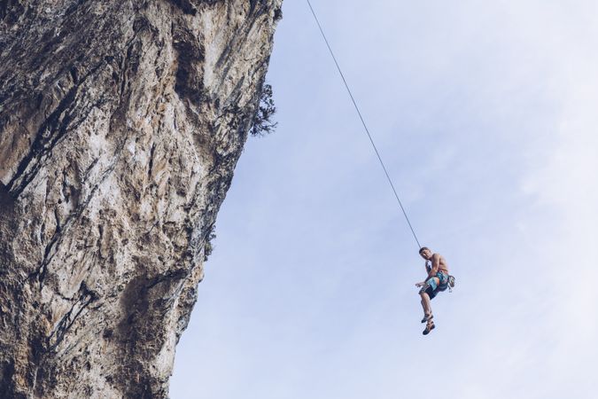 Anonymous climber handing on cliff