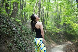 Athletic female smiling in colorful leggings in the forest