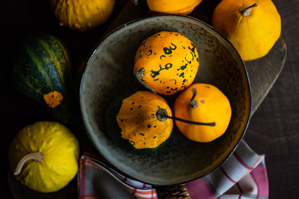 Top view of rustic bowl surrounded with squashes and kitchen towel