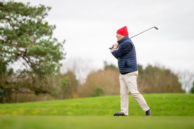 Man putting on golf course on over cast day