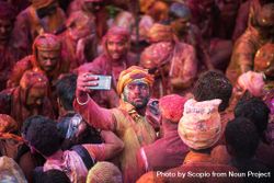 Man in crowd taking selfie during  Indian Holi festival 4OZlo5