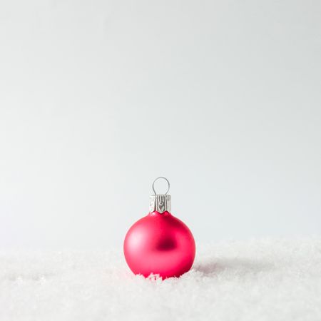 Pink Christmas bauble on snow