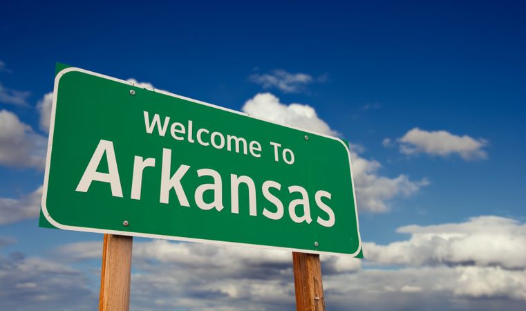 Welcome To Arkansas Green Road Sign Over Blue Sky with Some Clouds.