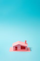 Pink paper house on blue background