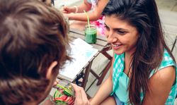 Friends talking with cocktails on outside table