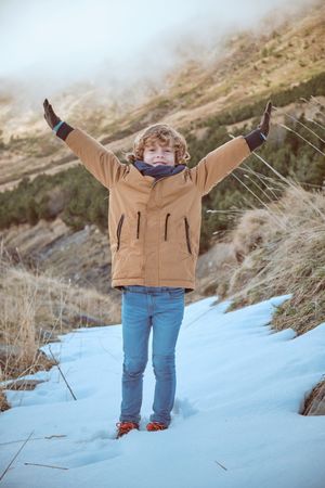 Happy child enjoying winter in mountains