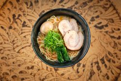 Bowl of traditional noddle dish with pork and nori in Asian restaurant